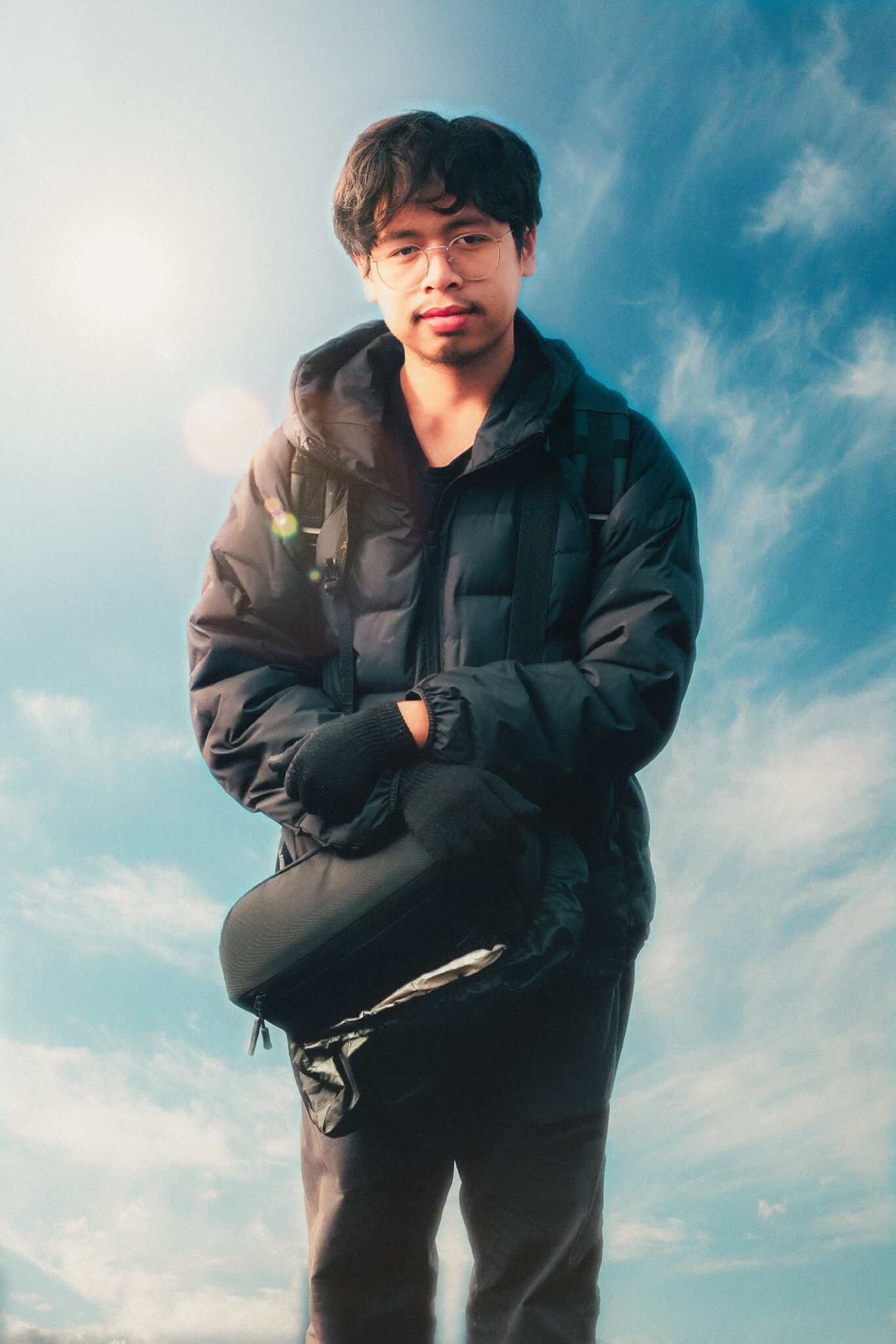 Portrait of Muhammad Daffa Dhaifurrahman outdoors against a blue sky