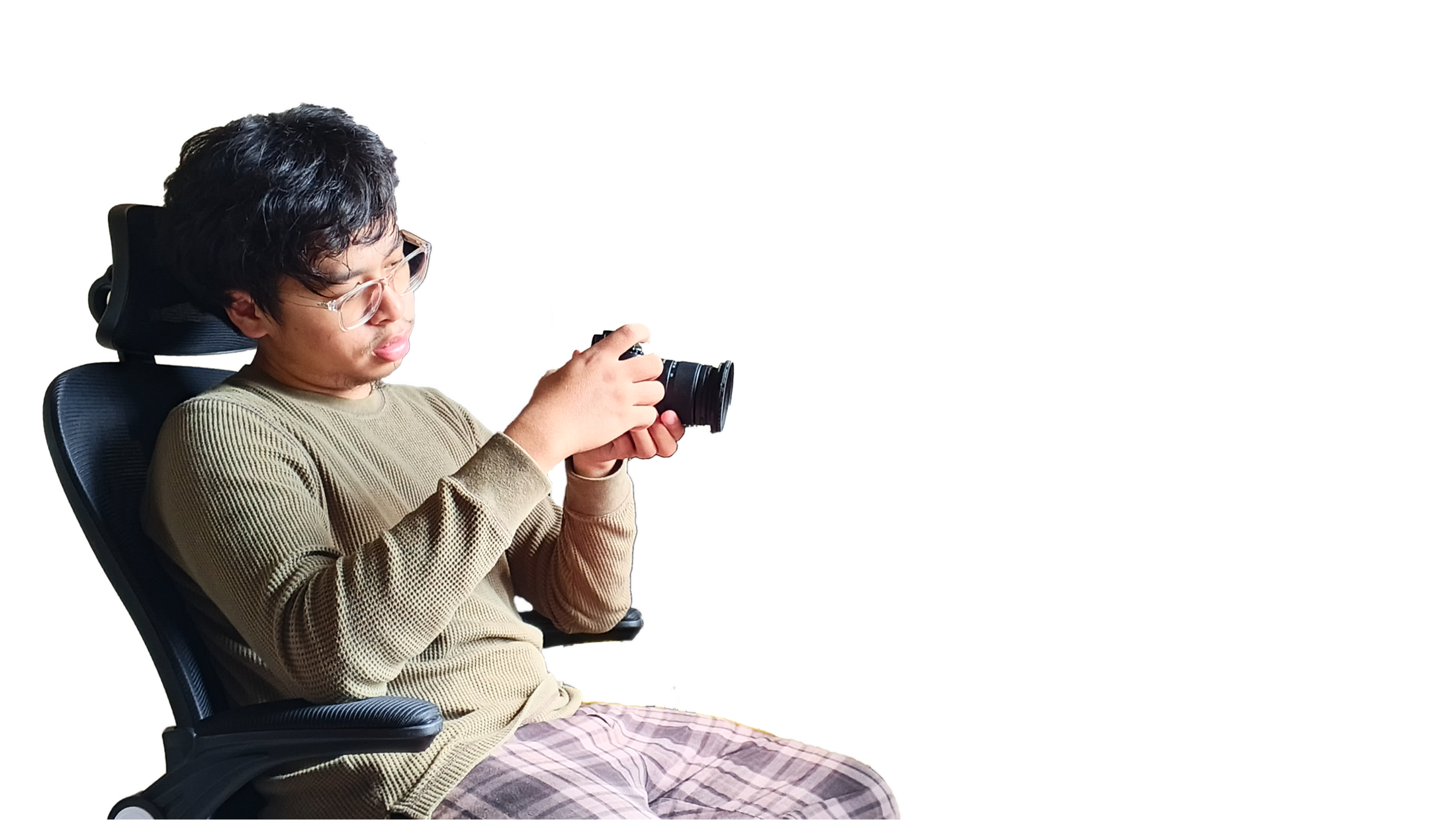 Muhammad Daffa seated in a studio, framing a shot through his camera